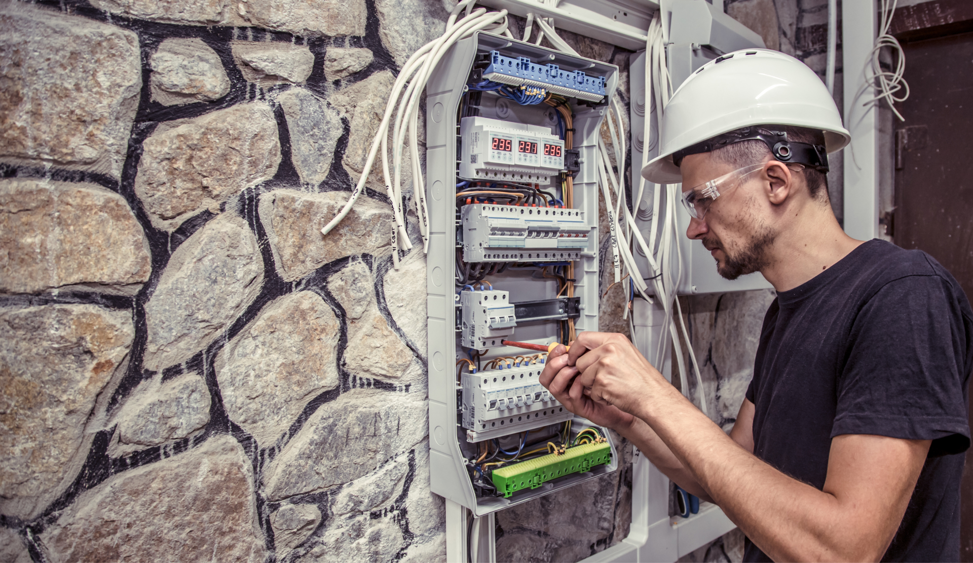 facility maintenance electrical working on panel and cables